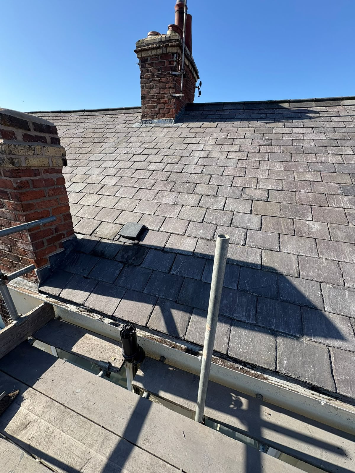 Natural slate roof with code-4 lead flashing dressed to brick chimney stack by RTC Roofing, Wirral