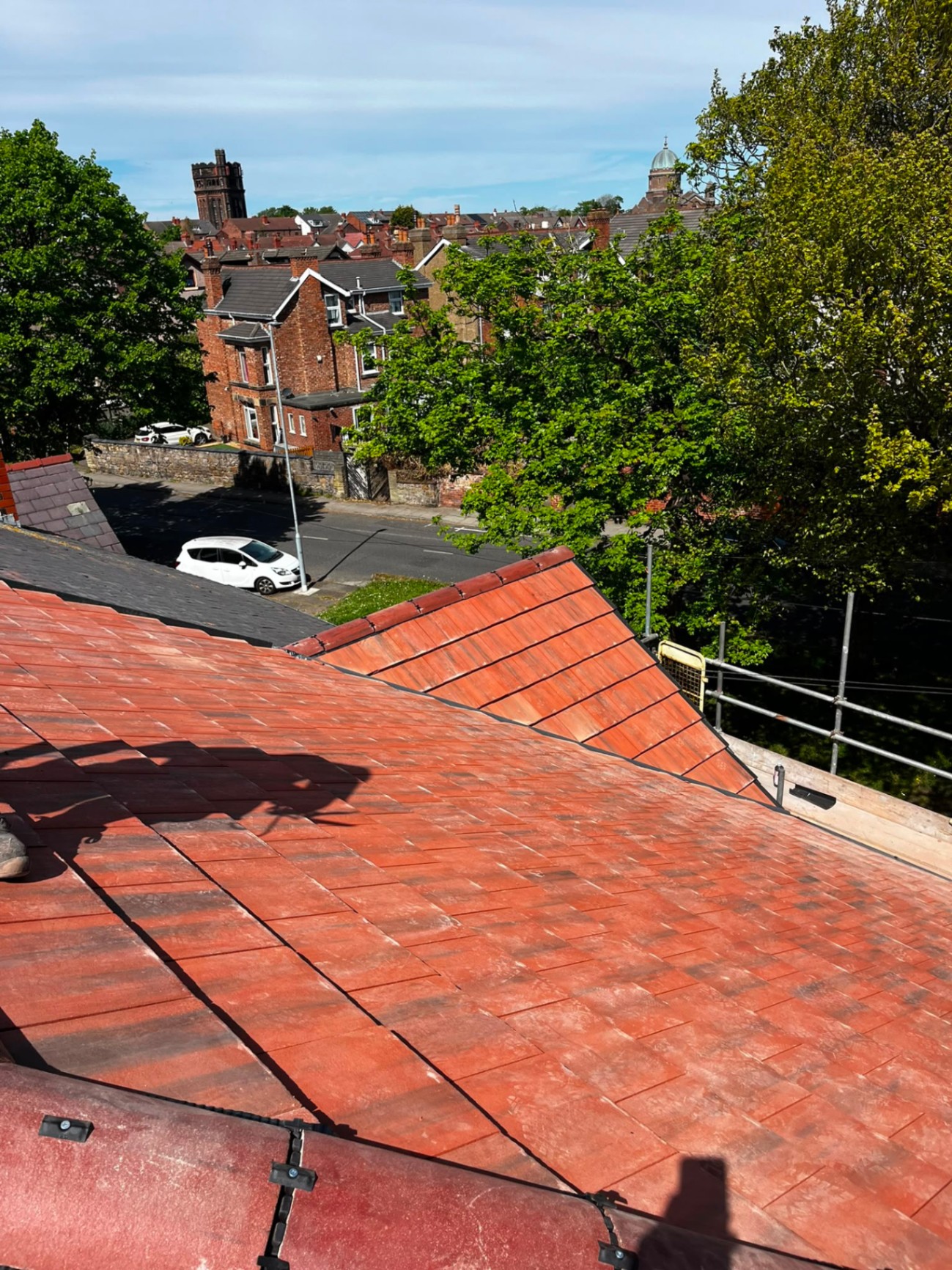 Rooftop view across a Wirral street of homes with mixed slate and tile roofs, from an RTC Roofing project site