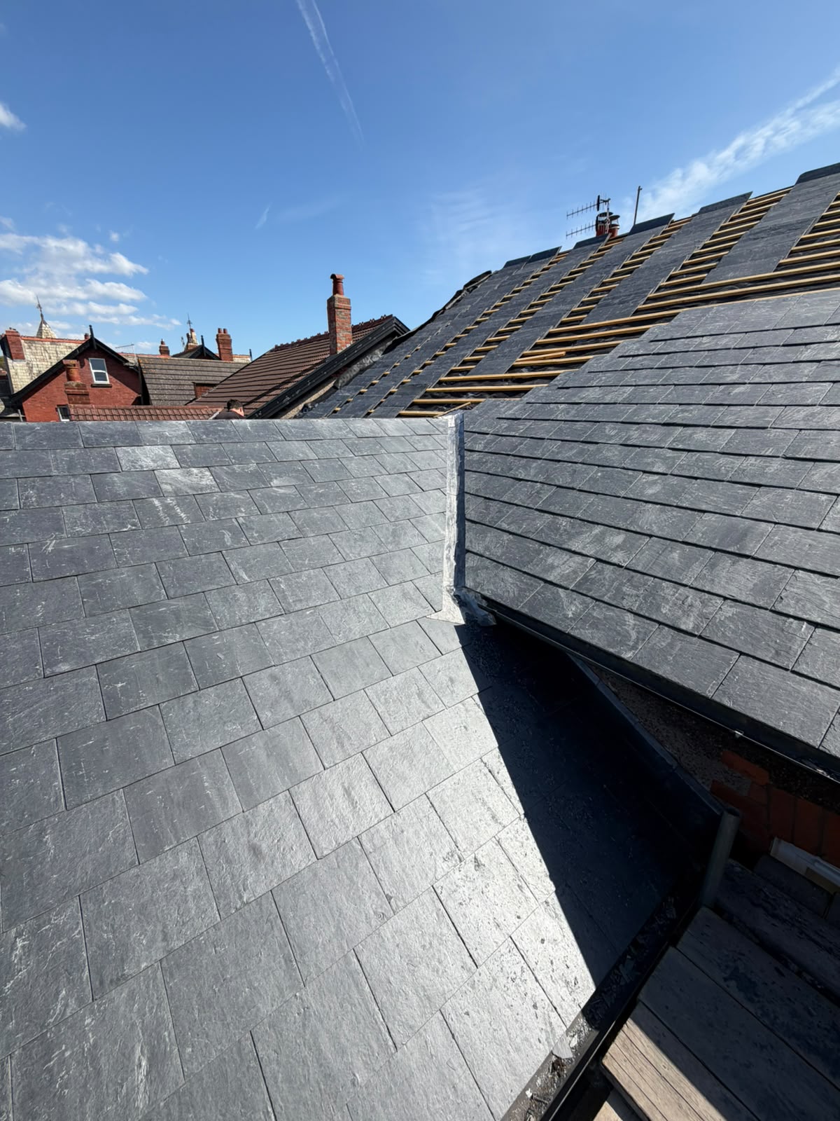 Completed natural slate re-roof with clean valley detail on a Merseyside terraced property by RTC Roofing