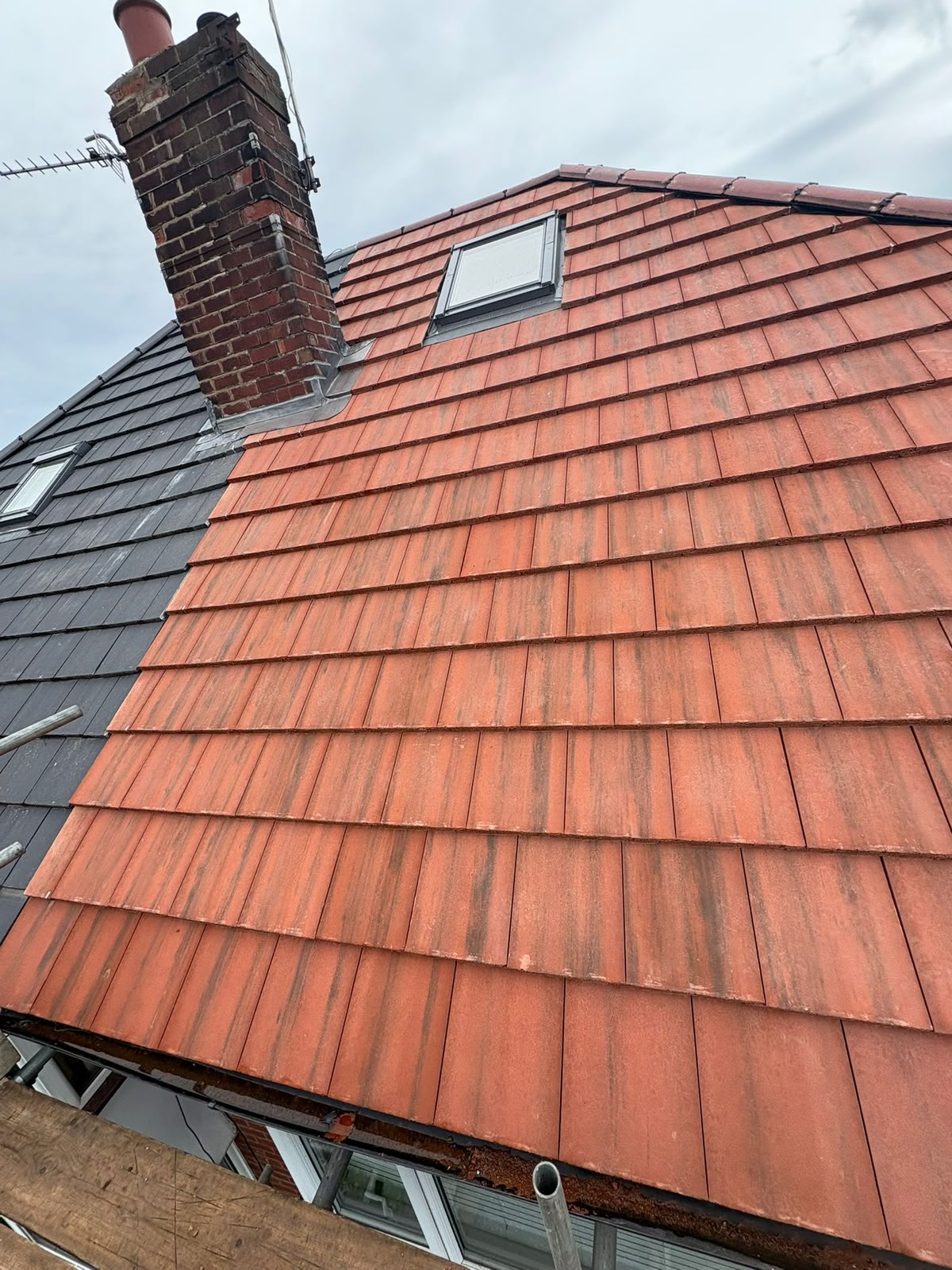 Fresh red clay plain tiles installed against slated adjoining roof and re-flashed chimney, RTC Roofing Merseyside